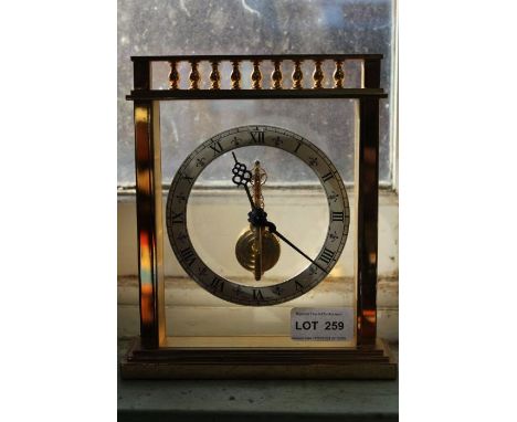 A Jaeger-Le Coultre mantel clock, with jewel set movement, the brass surround with baluster crest, the chaptering with Roman 
