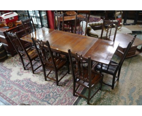 An oak Ercol extending dining table and eight high back dining chairs