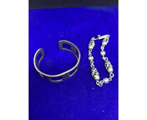 TWO HEAVY SILVER BRACELETS MARKED 925 TO INCLUDE A BANGLE AND A CELTIC STYLE 