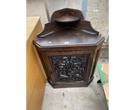 A LATE VICTORIAN OAK CORNER CUPBOARD WITH HEAVILY CARVED SINGLE DOOR AND SHAPED INTERIOR SHELF, 26" WIDE 