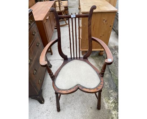 AN EDWARDIAN MAHOGANY ELBOW CHAIR WITH HEART SHAPED SEAT AND HARP STYLE BACK 