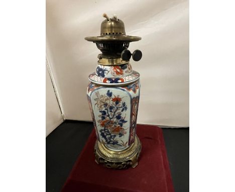 AN ORIENTAL CERAMIC AND BRASS OIL LAMP 