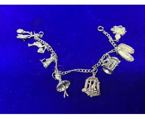 A SILVER CHARM BRACELET MARKED STERLING WITH EIGHT VARIOUS CHARMS IN A PRESENTATION BOX 