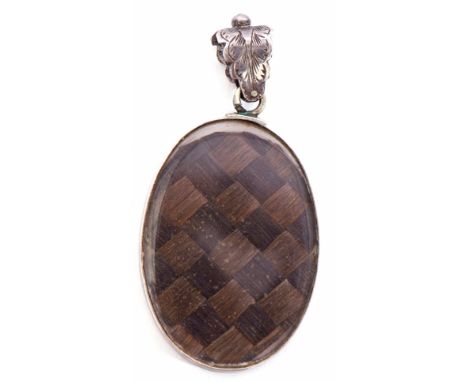 Antique mourning locket of oval form, glazed both sides with a plaited hair panel, engrave leaf bale, framed in a white metal