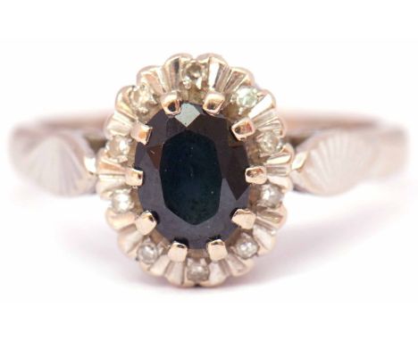 Sapphire and diamond cluster ring, the oval faceted sapphire within a surround of small diamonds, stamped 18ct, size H/I