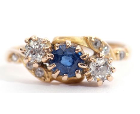 Late Victorian sapphire and diamond cross over ring, the centre a round cut faceted sapphire between two old cut diamonds, th