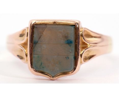 15ct stamped carved jade signet ring, the shield shaped jade carved panel with three fleur de lys in rub-over mounts to a pla