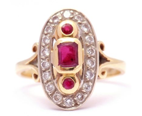 18ct gold ruby and diamond dress ring centring a stepped cut ruby between 2 round faceted rubies, each individually in rub-ov