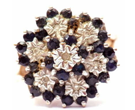 9ct gold, sapphire and diamond cluster ring, featuring seven small diamonds in illusion settings, surrounded by small dark sa