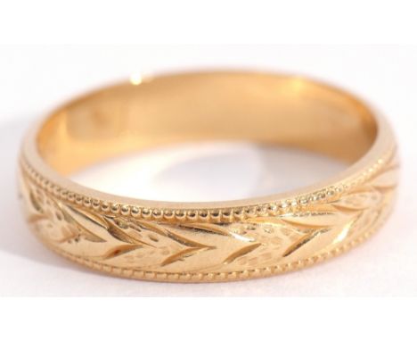 Wedding ring, stamped 750, engraved with a continuous foliate design between beaded edges, size K, weight 2.8gms