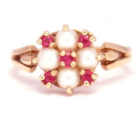 A 585 stamped seed pearl and ruby cluster ring, the 4 seed pearls interspersed with 4 small rubies, size K/L