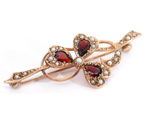 9ct gold, garnet and seed pearl brooch, a design of a three leaf clover entwined in a seed pearl surround and branch, 5cm lon