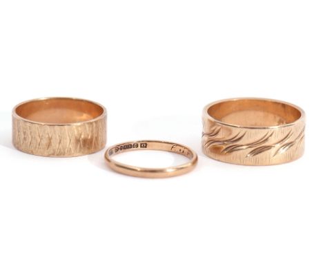 Mixed Lot: 9ct gold thin polished wedding ring, a 9ct gold wide band chased decorated wedding ring, together with a 10K stamp