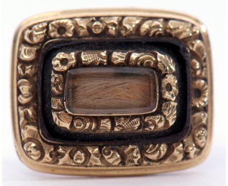 Georgian mourning brooch, centring a glazed plaited hair panel, framed and raised in a black onyx surround within a floral go