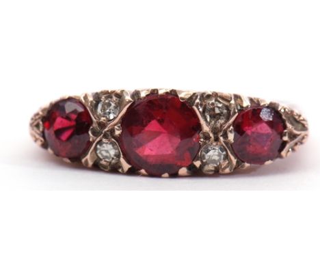 9ct gold garnet and diamond ring, featuring 3 graduated round faceted garnets, interspersed with 4 small diamonds, Birmingham