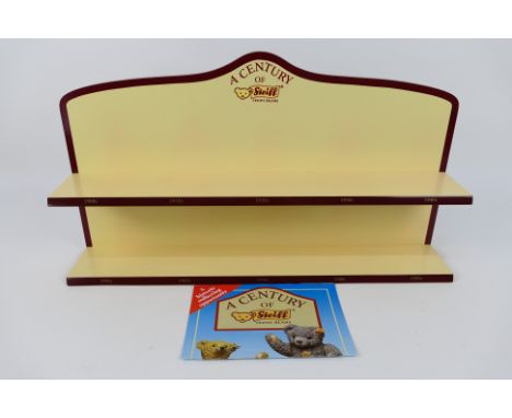 Steiff - A Steiff 'A Century of Steiff' wall mounted display rack. The rack measures approximately 59cms (L) 32cms (H) x 11cm