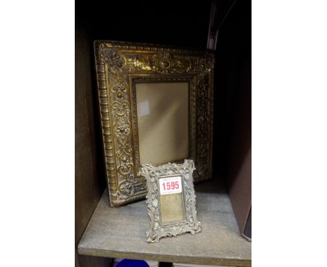 An embossed brass photograph frame, 24.5 x 21cm; together with another small easel back example. 