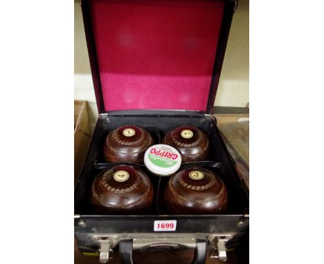 A cased set of four lignum vitae bowls, stamped 'R G Lawrie, Glasgow'.&nbsp; 