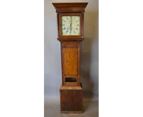 A George III Oak Long Case Clock, the square hood with turned pilasters above a rectangular door and conforming plinth base, 