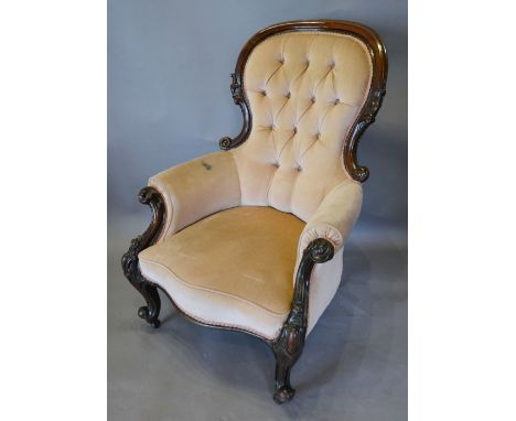 A Victorian Walnut Drawing Room Armchair, the partly carved and button upholstered back above a stuff over seat flanked by sc