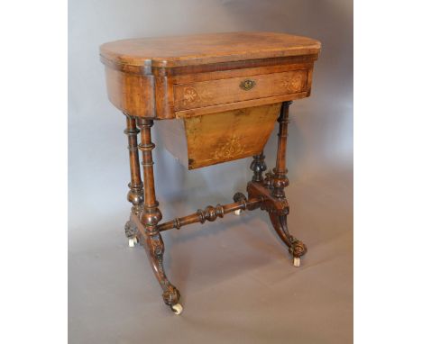 A Victorian Walnut Games/Work Table, the hinged top with backgammon and chess board above a marquetry inlaid frieze drawer an