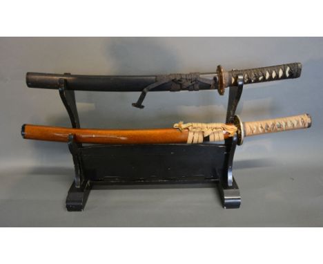 A Japanese Wakizashi with Lacquered Scabbard, together with another similar, both upon a lacquered stand, 60 and 70 cms long