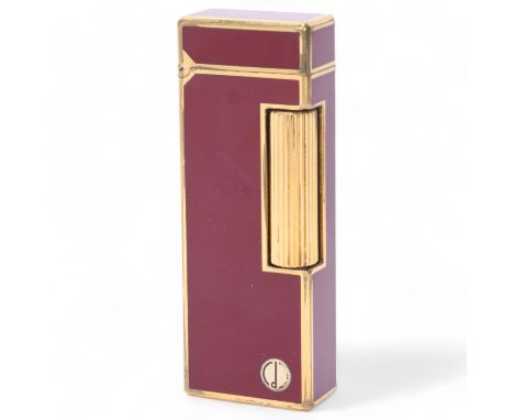 A vintage Dunhill Rollagas lighter, with gold plated and red lacquer body, makers marks to base, length 6.3Some surface marks
