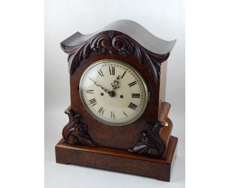 An early Victorian walnut mantel clock, the case with foliate decoration and fitted with a cream painted dial, the repeating 