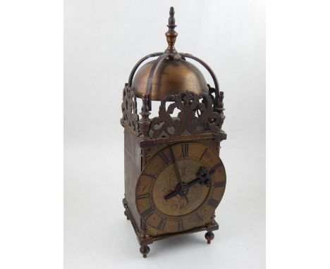 A late Victorian mechanical winding brass lantern clock, the chapter ring with Roman numerals, having foliate engraved dial. 