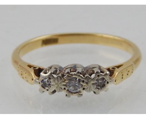 A diamond three stone ring claw set in an 18ct yellow gold band.