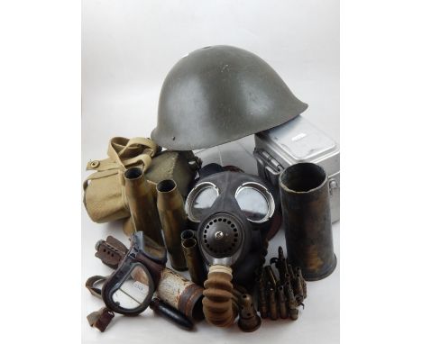 A collection of militaria, including a mk.4 gas mask, water bottle, spent ammunition cartridges, steel helmet and a pair of g