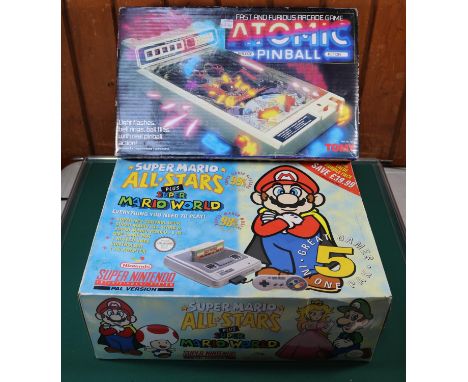 A Super Nintendo games console. An early 1990s console with one controller, instructions and 2x games; Donkey Kong Country 3 