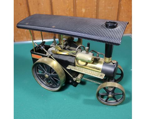 A live steam Wilesco single cylinder traction engine. With burner and some accessories in black and brass livery. Together wi