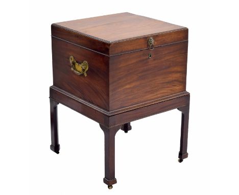 George III mahogany cellarette on stand, the hinged cover enclosing an open interior, with two brass lion mask and ring handl
