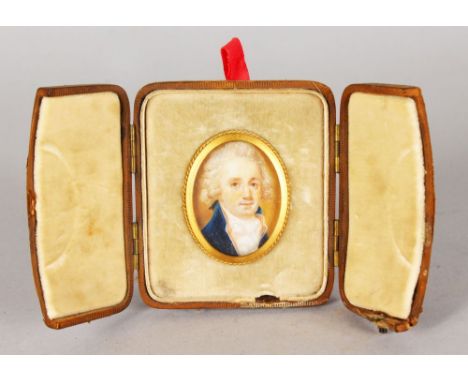 A SMALL 18TH CENTURY OVAL PORTRAIT MINIATURE OF A GENTLEMAN, wearing a blue coat and white cravat. 4cms x 2.75cms in a gilt f