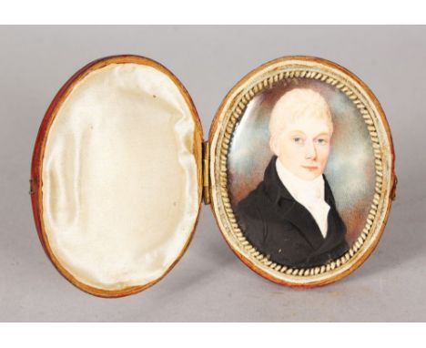 AN EARLY 19TH CENTURY OVAL PORTRAIT MINIATURE OF A YOUNG MAN with blonde hair, black coat and white cravat. 6.5cms x 5cms in 