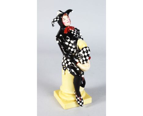 A ROYAL DOULTON FIGURE OF A JESTER, pattern HN71, wearing a black and white chequered cloak, hat and shoes, sitting on a yell