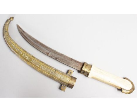 A TURKISH DAGGER with curving blade, bone handle and engraved brass sheath. 15ins long.