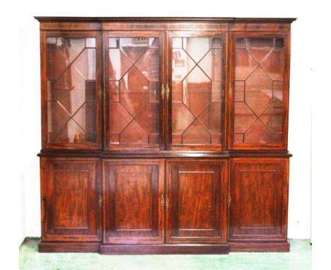A GOOD GEORGIAN MAHOGANY BREAKFRONT BOOKCASE, the top with dentil cornice, four glazed astragal doors, enclosing adjustable s