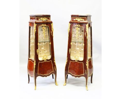 A PAIR OF LOUIS XVI STYLE MAHOGANY AND ORMOLU PEDESTAL VINTAGE CABINETS, with marble tops, glazed doors and side panels, sati