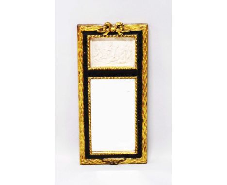 A GILT MIRROR with a panel of cupids. 1ft 9ins long.