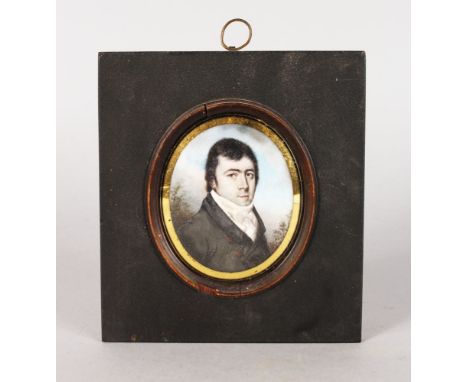 AN 18TH CENTURY OVAL PORTRAIT MINIATURE OF A GENTLEMAN wearing a dark coat and white cravat. 7cms x 5.5cms, in a wooden frame