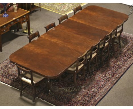 A large ten-twelve seat Regency style mahogany extending twin pedestal dining table. D-shaped top raised on turned pedestals,