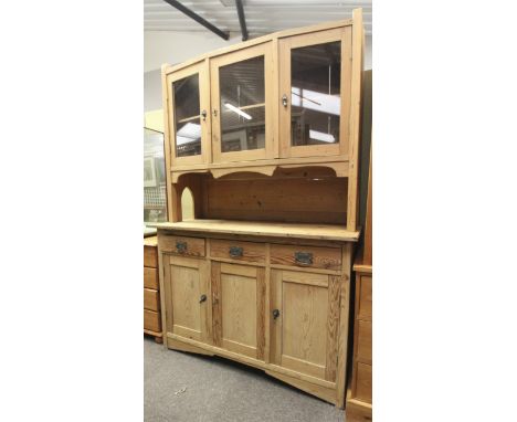 A 20th century pine dresser. Glazed upper cupboard consisting of three doors (two folding) and a three quarter gallery above,