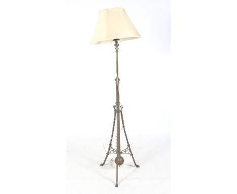 A late 19th century Aesthetic Movement brass telescopic standard lamp. With scroll details on a tripod support. Height to fit