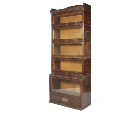 A Globe Wernicke style unit, 'The Lebus'. The oak five section tall glazed bookcase/display cabinet with drawer below and bra