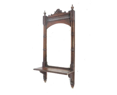 A late 19th century Neo-Gothic mahogany wall mirror. With gathered column sides, pierced topped section and bevelled glass wi