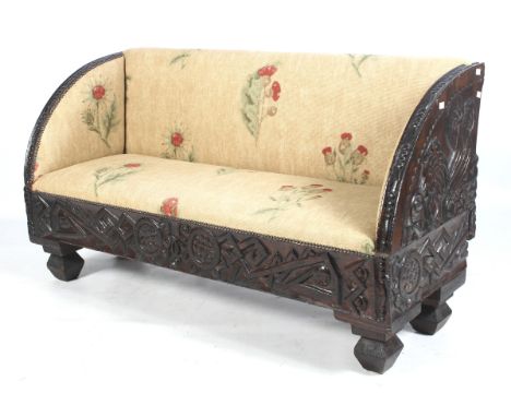 A circa 1900 carved and stained pine two-and-half seat upholstered Continental sofa. With stylised cockerel decoration to end