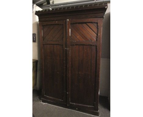 A 19th century Neo-Gothic style pine two door wardrobe. Having four fitted drawers and turned wooden coat hooks arranged arou