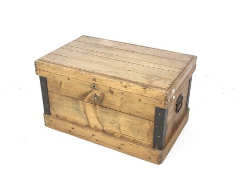 A vintage pine travel trunk. With metal bound corners and drop handles to the ends. Plank sides and top, on a plinth base. L8